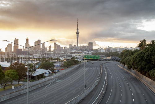 Auckland skyline at sunset with an empty freeway in the foreground